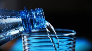 Bottled water being poured into a glass.